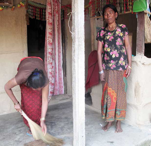 Sita Kumal sweeps the front porch of their house as Ramkumari Kumal, her mother-in-law, looks on  Photo: ICIMOD